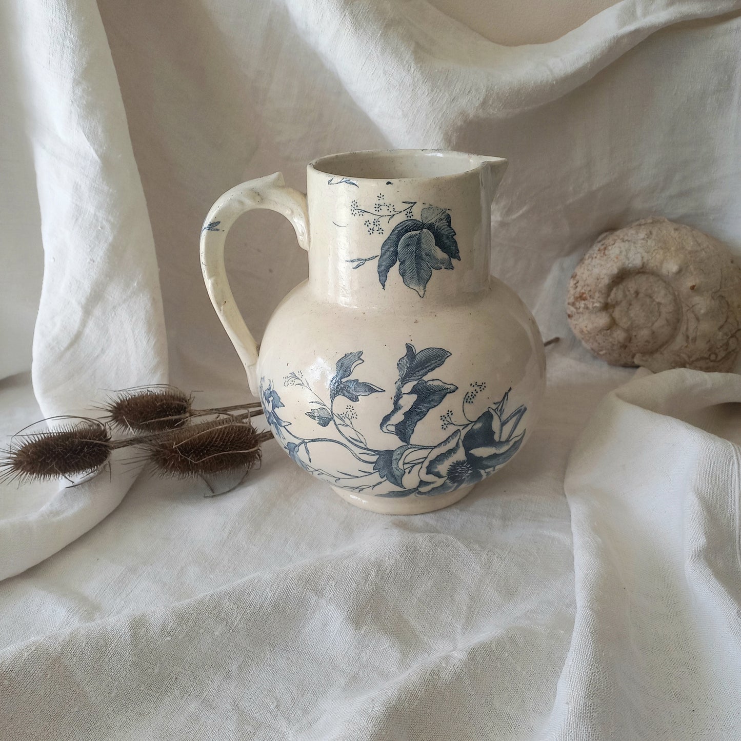 A large and beautiful French antique ironstone jug in a lovely aged white with blue floral transfer pattern. This wonderful piece of ironstone history has a super patina of age that gives it that look we all admire.