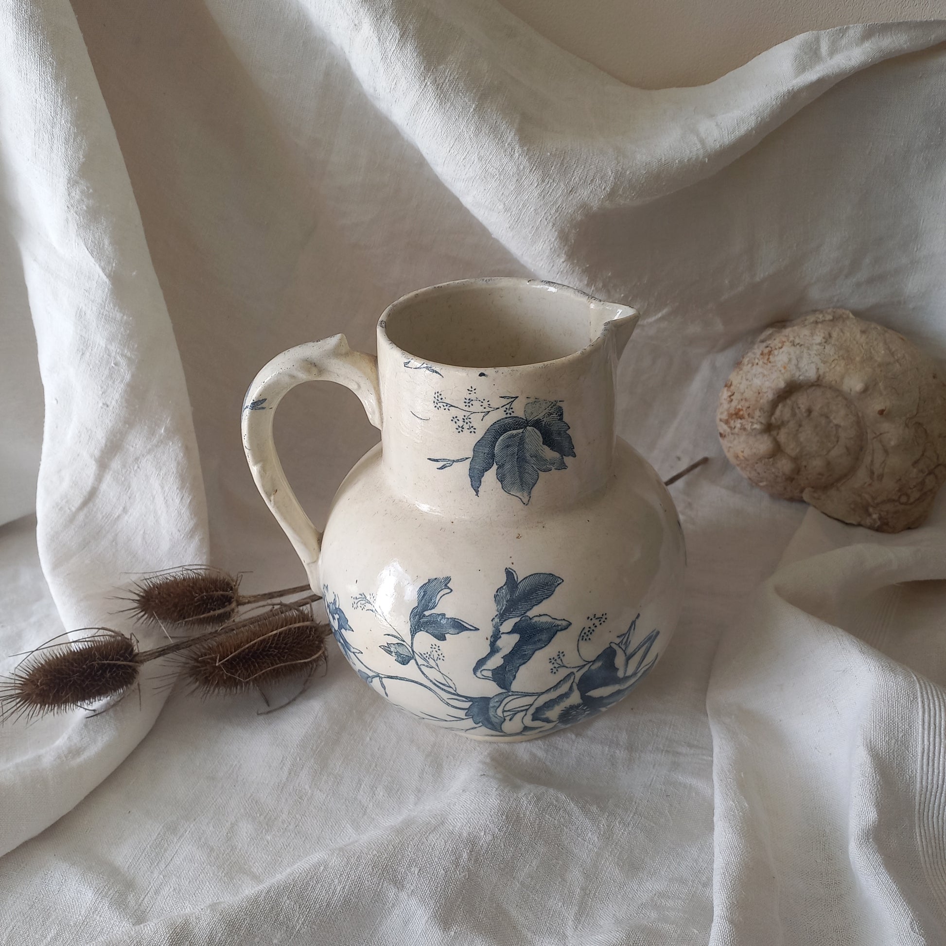 A large and beautiful French antique ironstone jug in a lovely aged white with blue floral transfer pattern. This wonderful piece of ironstone history has a super patina of age that gives it that look we all admire.