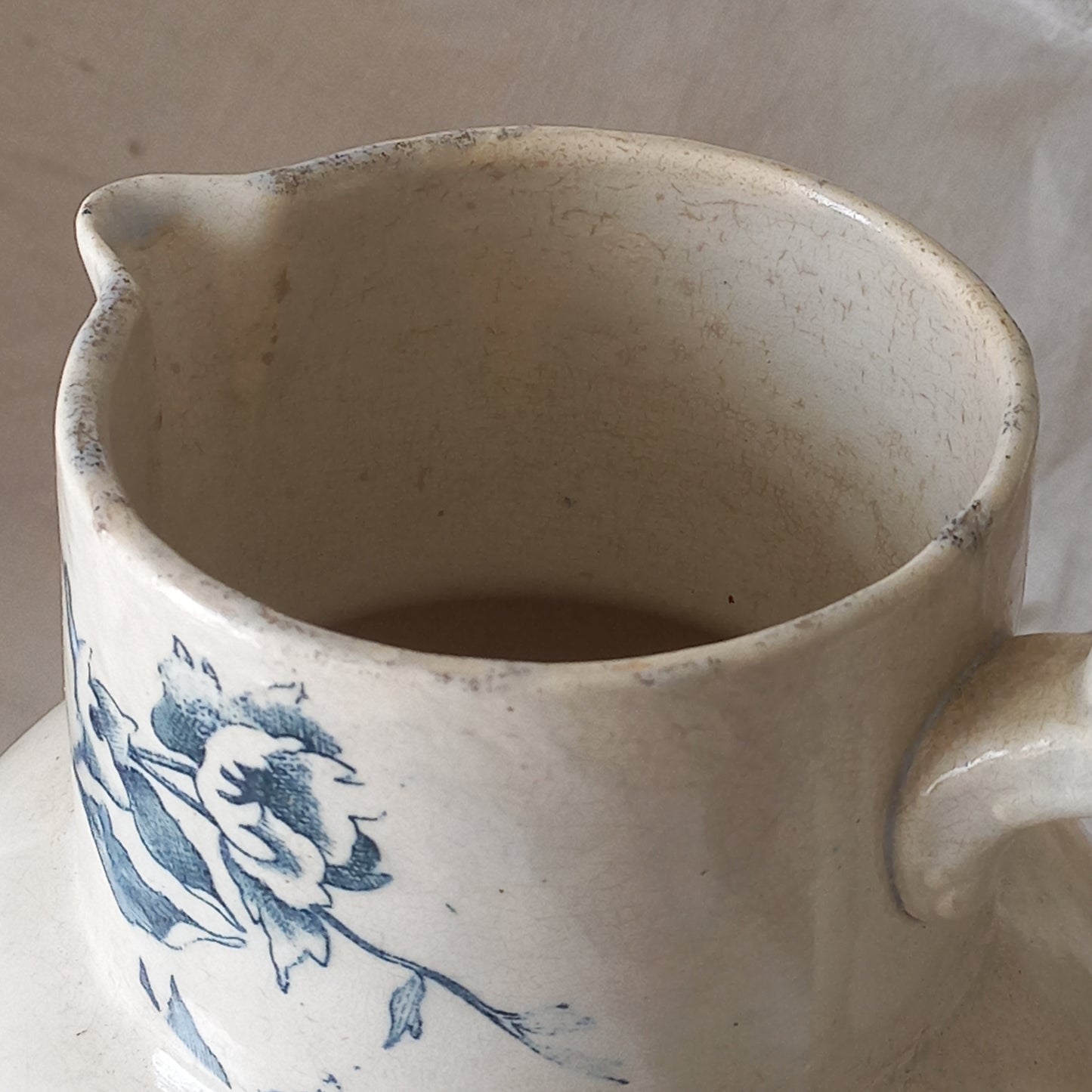 A large and beautiful French antique ironstone jug in a lovely aged white with blue floral transfer pattern. This wonderful piece of ironstone history has a super patina of age that gives it that look we all admire.