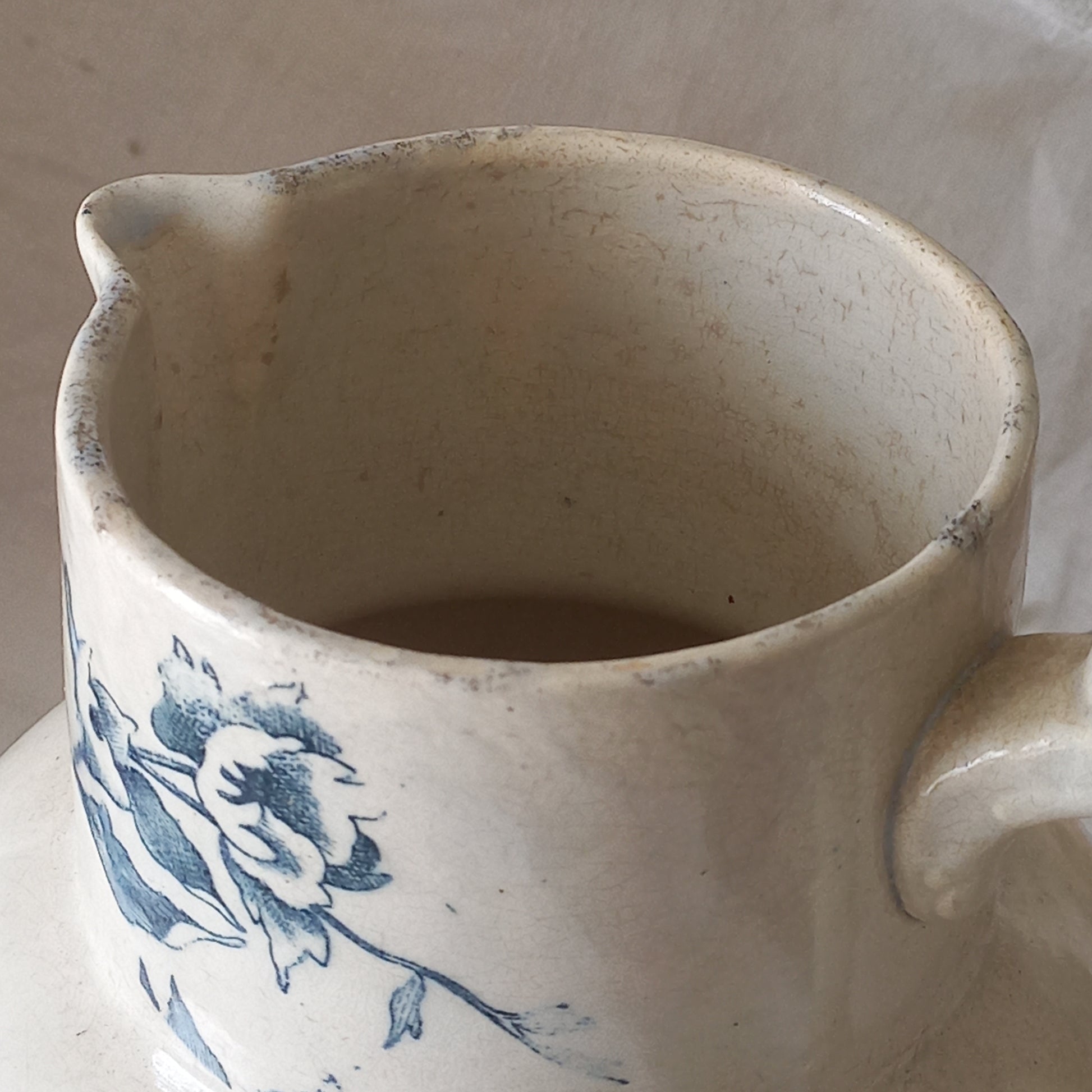 A large and beautiful French antique ironstone jug in a lovely aged white with blue floral transfer pattern. This wonderful piece of ironstone history has a super patina of age that gives it that look we all admire.