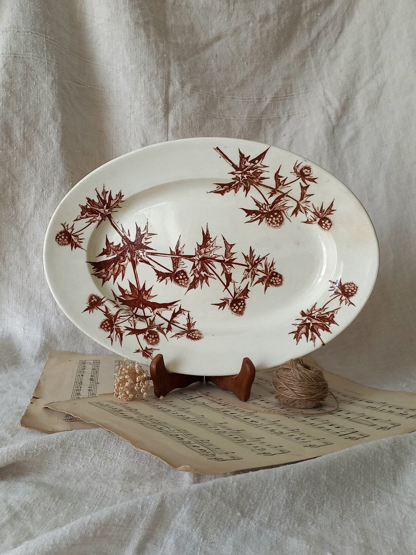 White plate with brown floral pattern on a textured surface