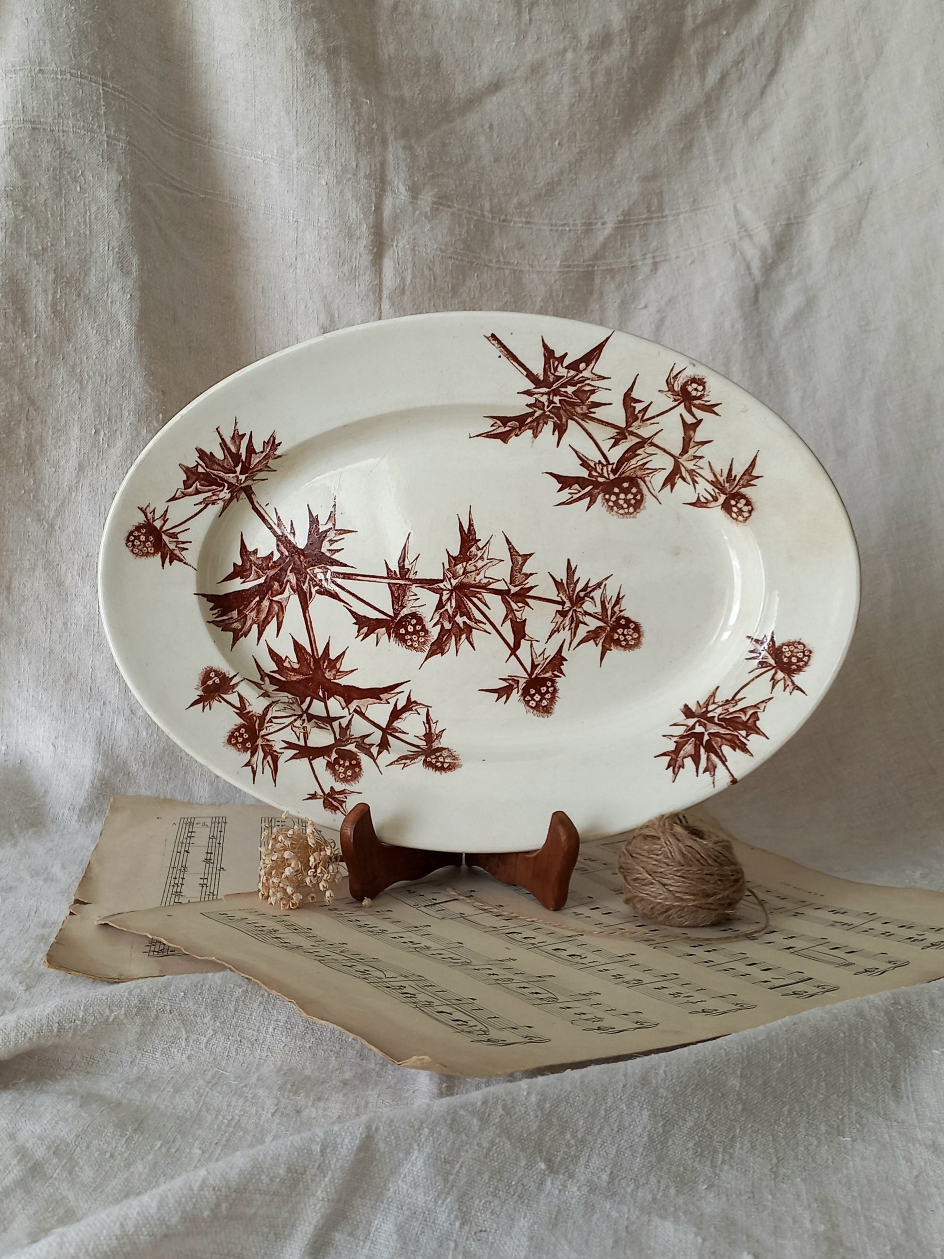 White plate with brown floral pattern on a textured surface