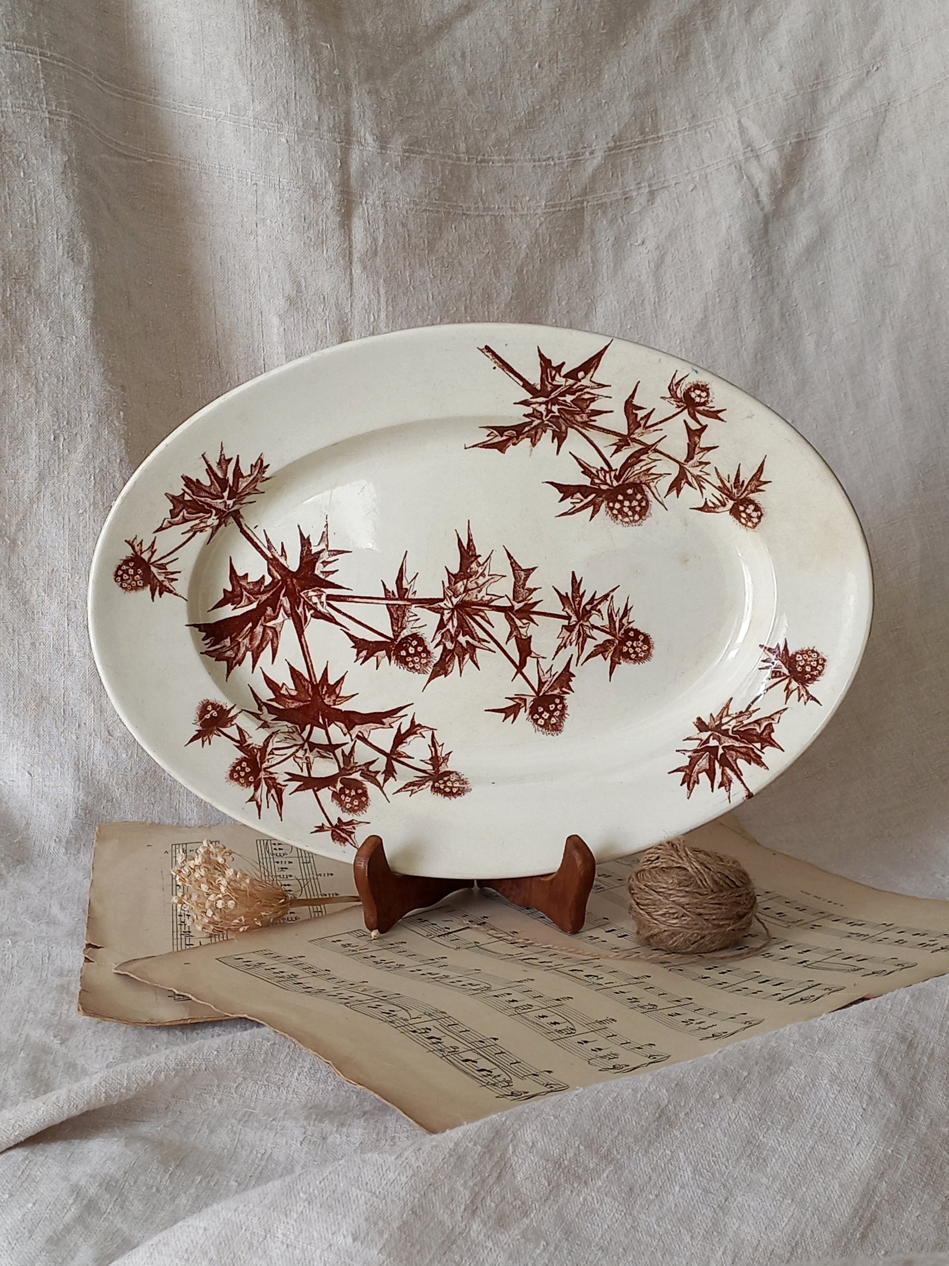 Decorative plate with brown floral pattern on a textured surface