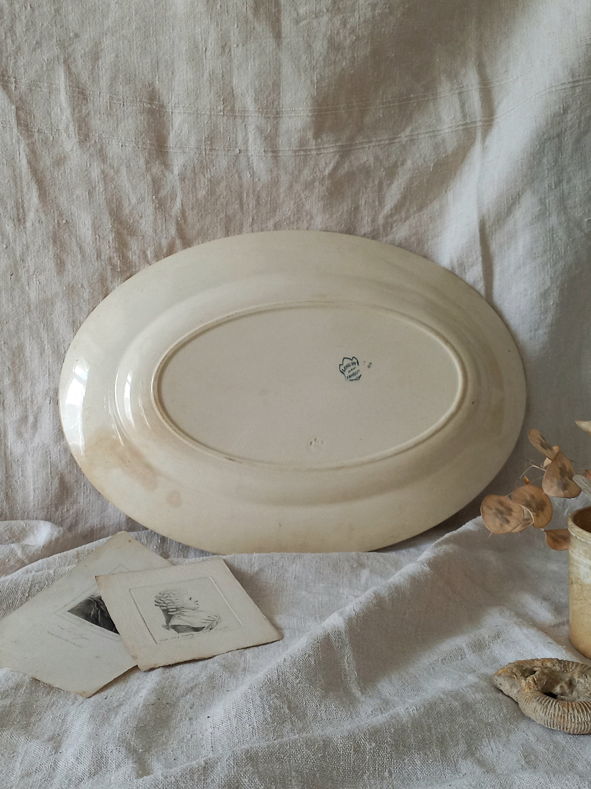 French antique oval ironstone serving plate with teal colour sunflower transferware pattern that over many decades has become a pleasing, warm shade of creamy white with crazing and tea-staining. 