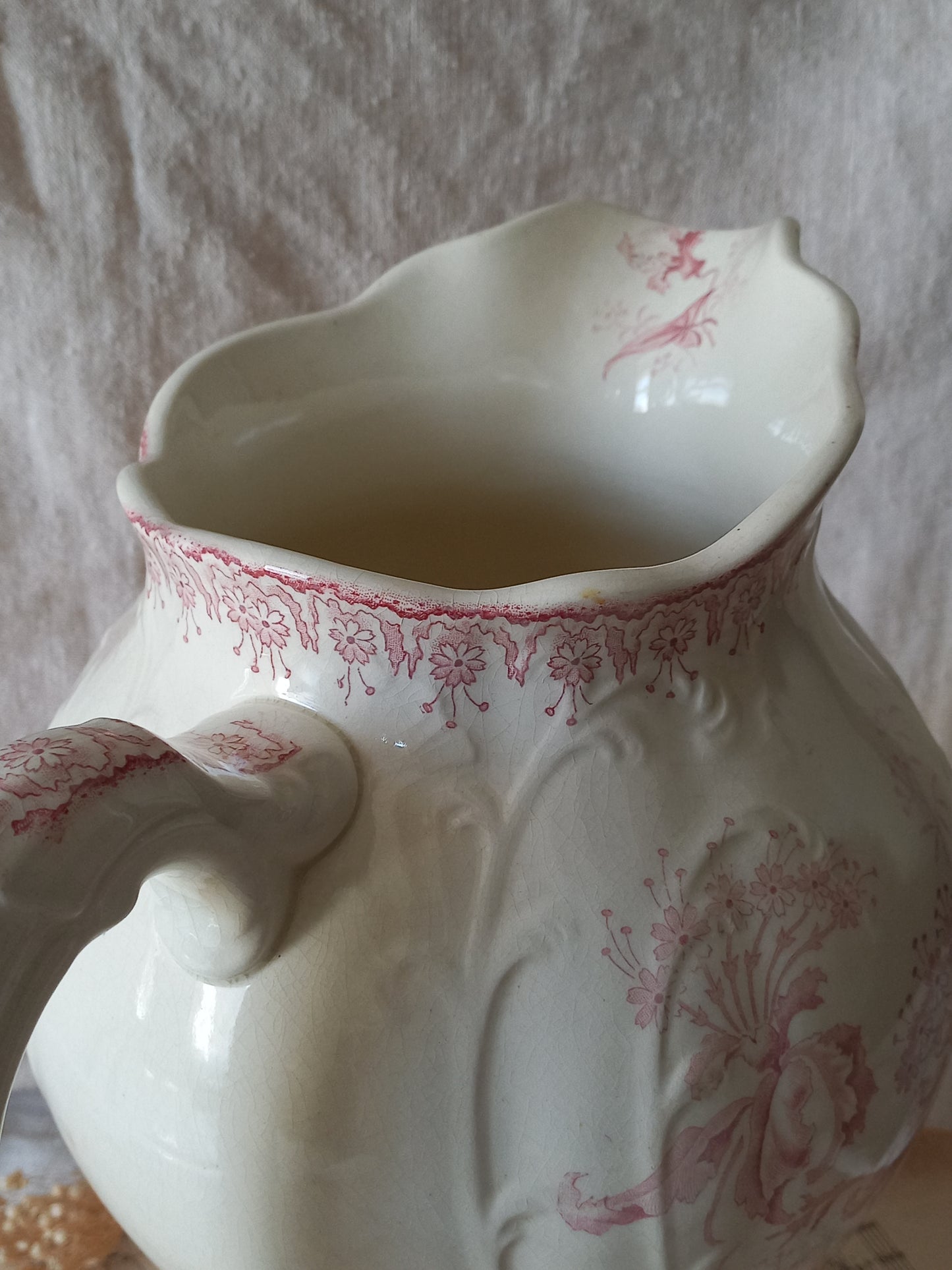 Close-up of Large French antique ironstone jug in a decorative setting.