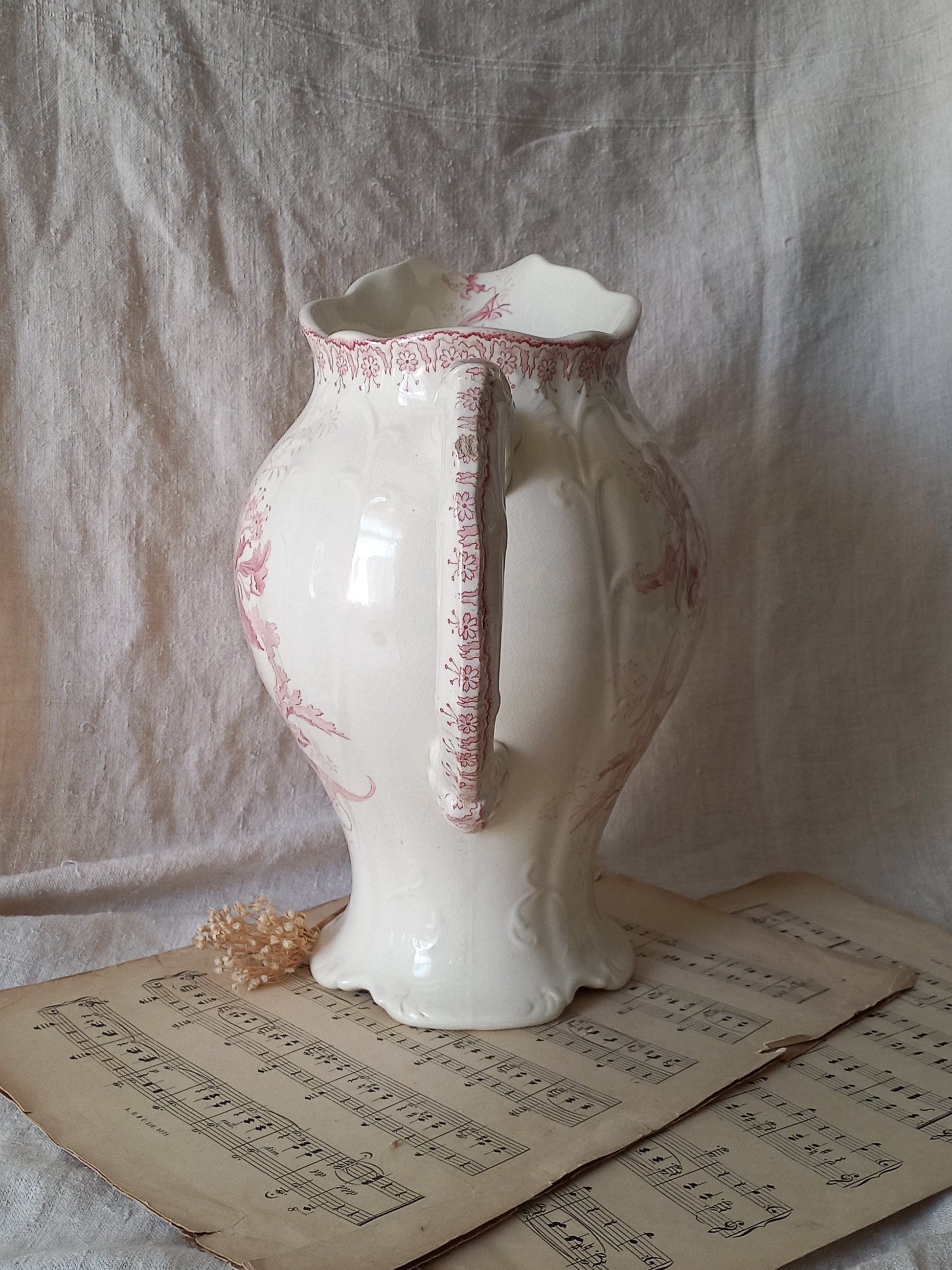 Large French antique ironstone jug in a decorative setting.
