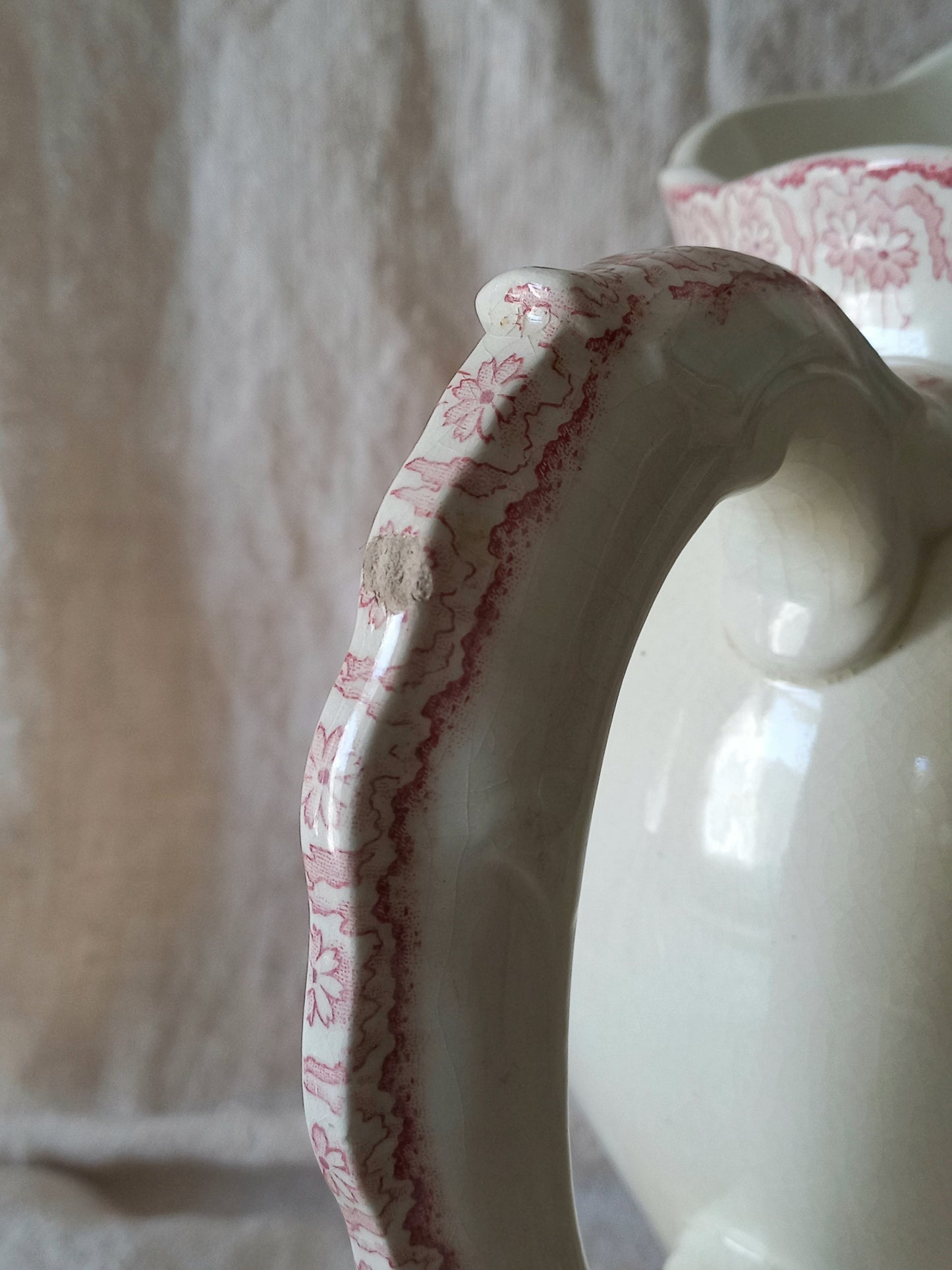 Close-up of Large French antique ironstone jug in a decorative setting.