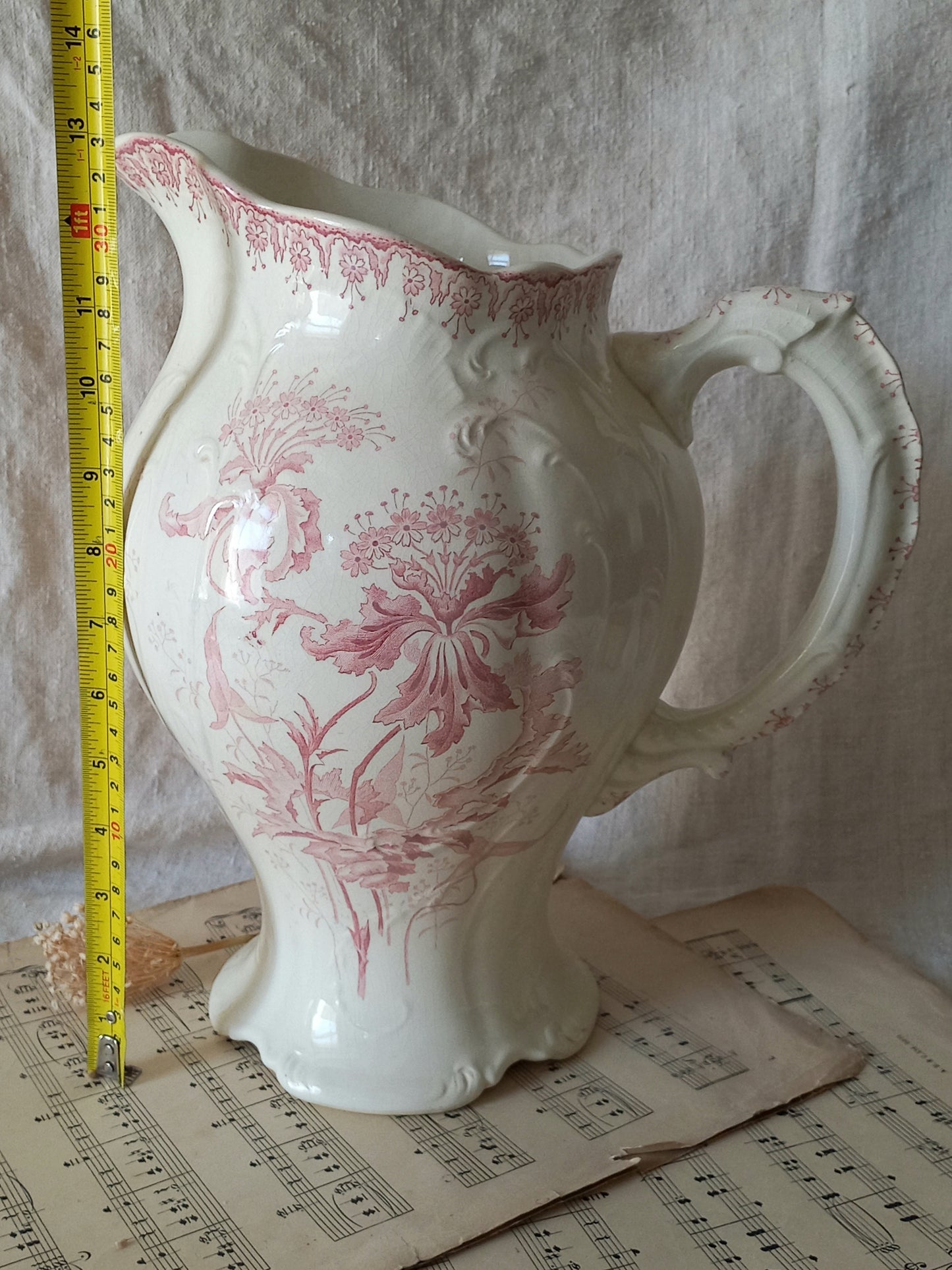 Large French antique ironstone jug in a decorative setting with tape measure for reference.