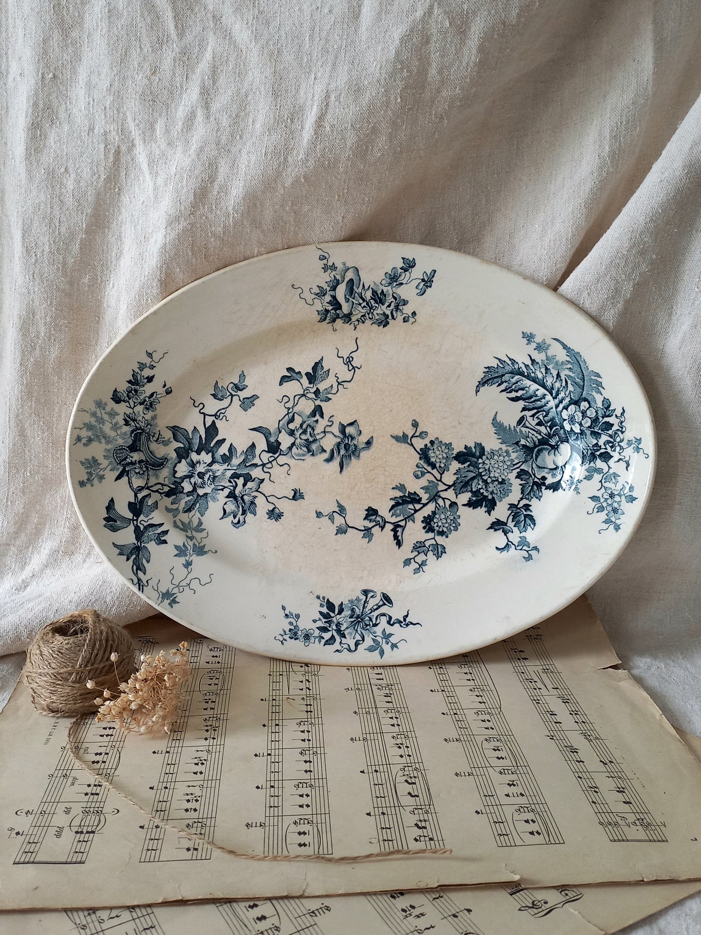 Decorative plate with blue floral patterns on a sheet of music