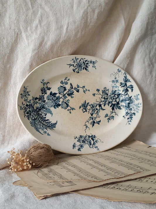 Decorative plate with blue floral patterns on a light fabric background