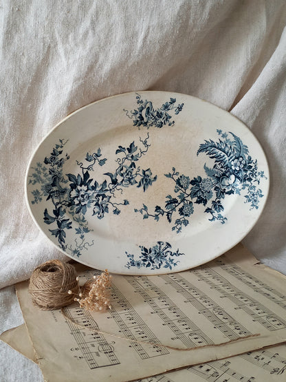 Oval ceramic plate with blue floral patterns on a light fabric background