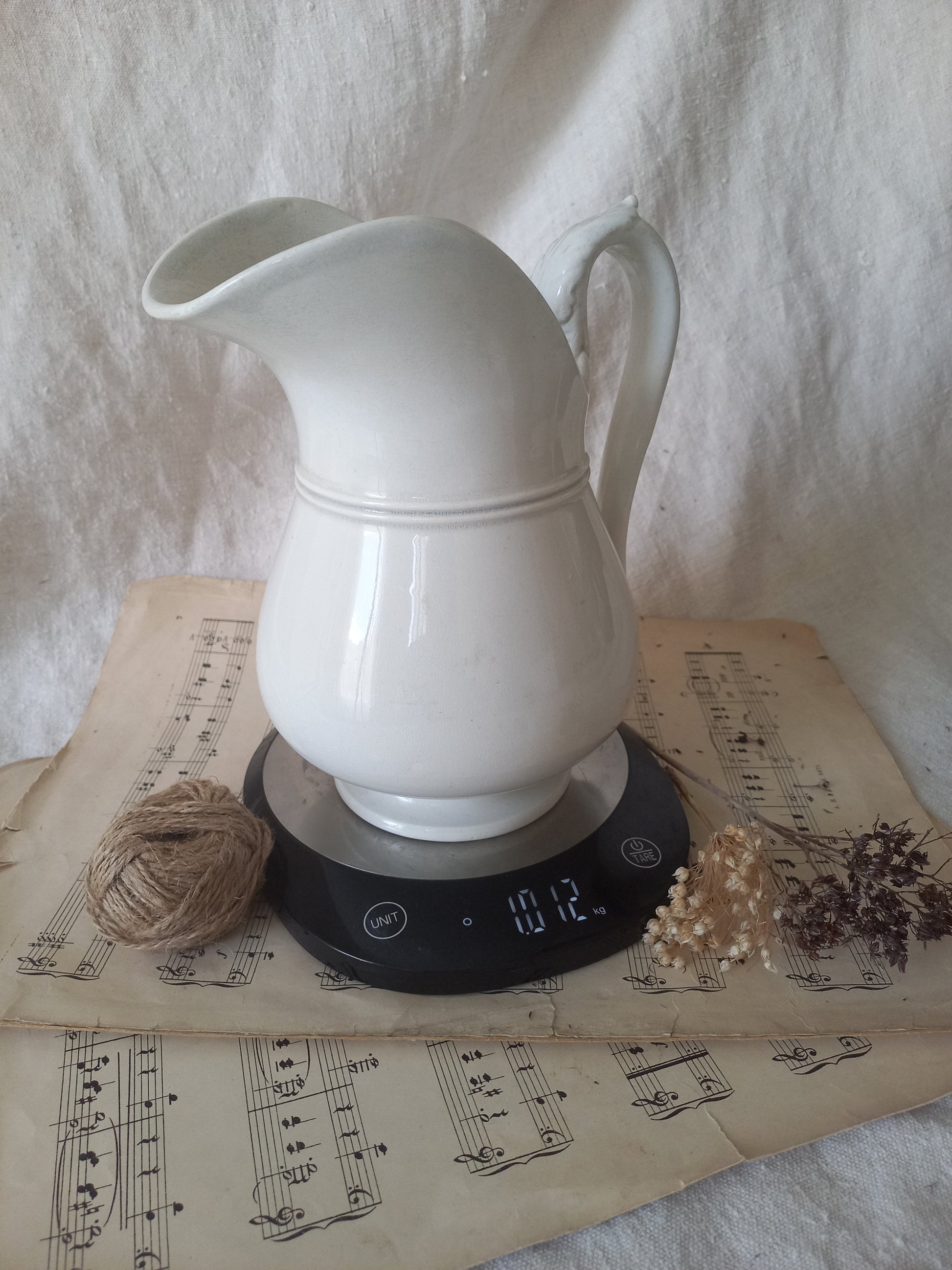 French antique white ironstone jug or pitcher with swan neck handle in a decorative setting.
