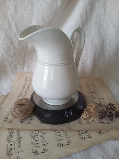 French antique white ironstone jug or pitcher with swan neck handle in a decorative setting.