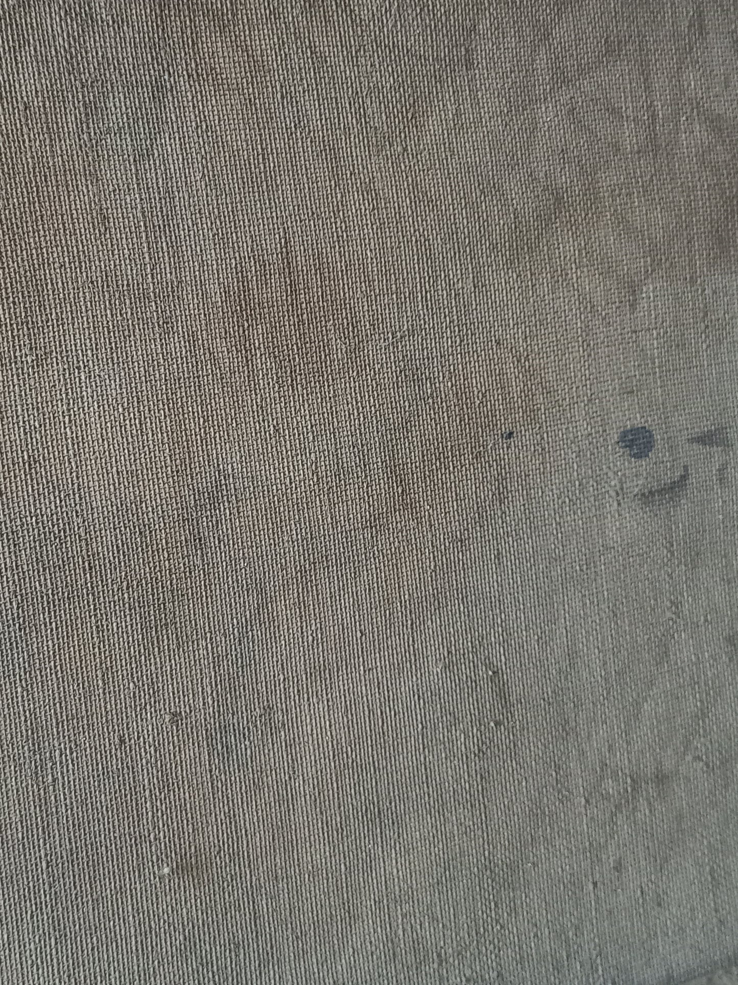 A close-up of a textured stretched canvas in a muted taupe-gray color, showing the detailed knit pattern and subtle tonal variations.