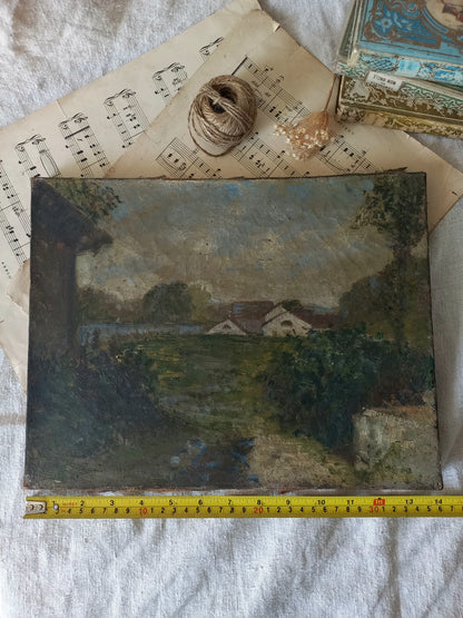 An oil landscape painting of a rural scene with houses, trees, and a stream, displayed on a white fabric background with vintage sheet music, string, a shell, and a yellow measuring tape below it.