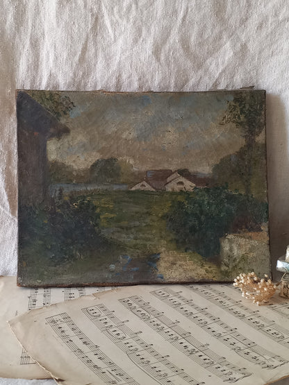 An antique oil landscape painting on canvas depicting a quiet village scene, styled on top of vintage sheet music against a textured white fabric background.