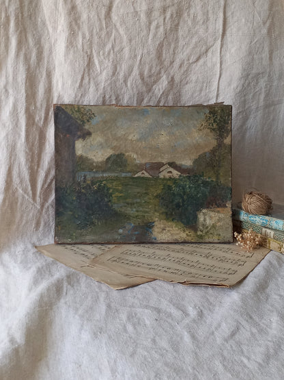 An antique oil landscape painting on canvas depicting a rural scene with houses, trees, and a path, displayed on a draped white linen cloth with vintage papers and twine.