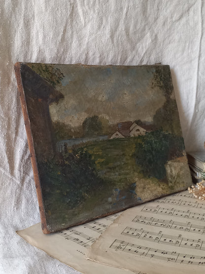 An antique oil landscape painting on canvas, depicting a rural scene with houses, trees, and a path, displayed on top of vintage sheet music against a draped white fabric background.