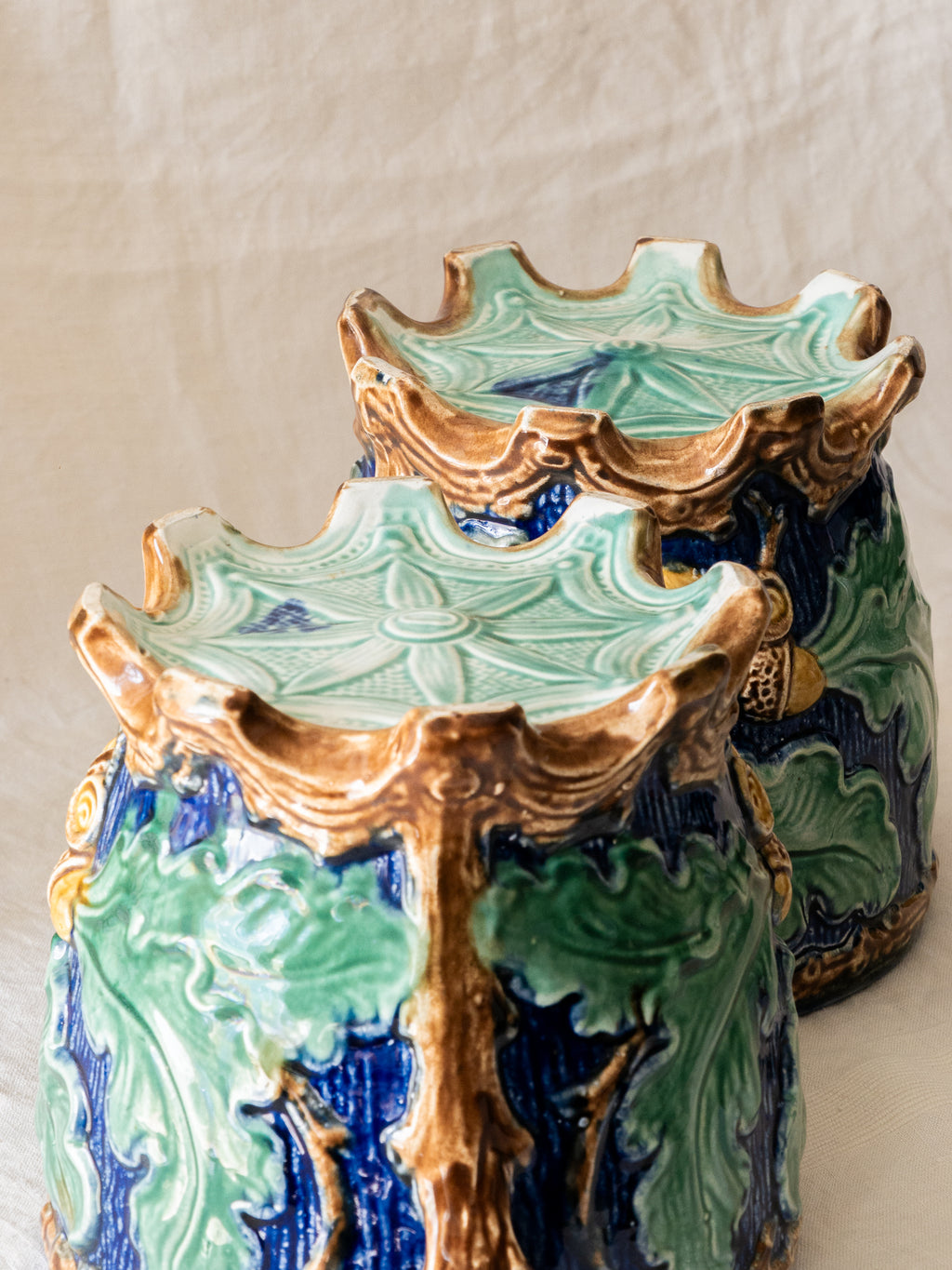 A stunning pair of French antique majolica planters, absolutely glorious fresh blue and green colours with oak leafs and acorns in relief making these stunning pieces of interior home decor wherever you decide to display them.

One of the planters has an antique repair in the form of metal staples that have been expertly done from the inside - in the 1800s and early 1900s this was quite a common repair to have made on items of high value and we feel it only adds to the authenticity/story of these pieces.
