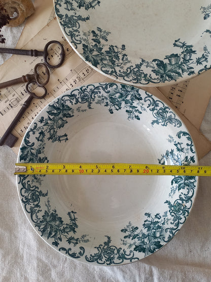 Two ceramic plates with floral patterns and a measuring tape between them on a textured surface.