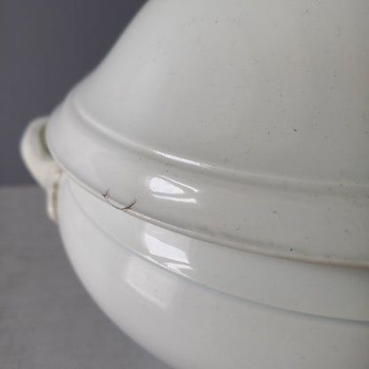 A small sized antique white ironstone soup tureen with elegant curves by French manufacturer Saint Amand et Hamage. This lovely old tureen has beautiful detailed handles either side of the tureen and on the lid. Circa late 19th to early 20th century.