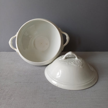 A small sized antique white ironstone soup tureen with elegant curves by French manufacturer Saint Amand et Hamage. This lovely old tureen has beautiful detailed handles either side of the tureen and on the lid. Circa late 19th to early 20th century.