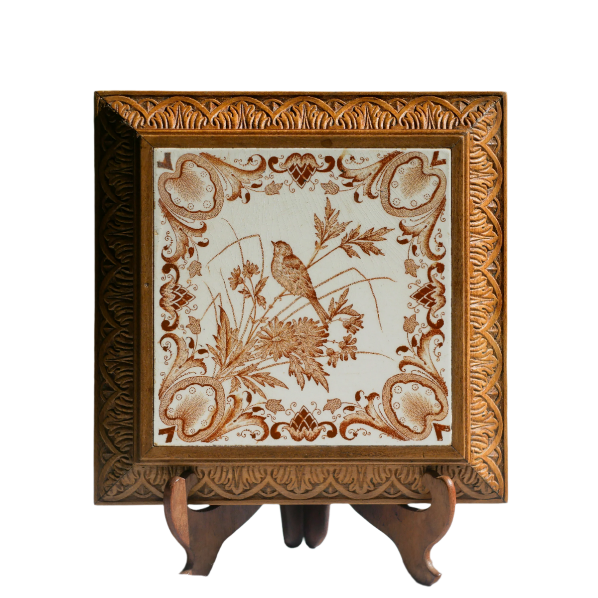Dessous-de-plat décoratif ancien en céramique avec oiseau et cadre en bois sculpté