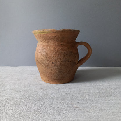 Small rustic vintage pottery jug with ochre glazed interior from France