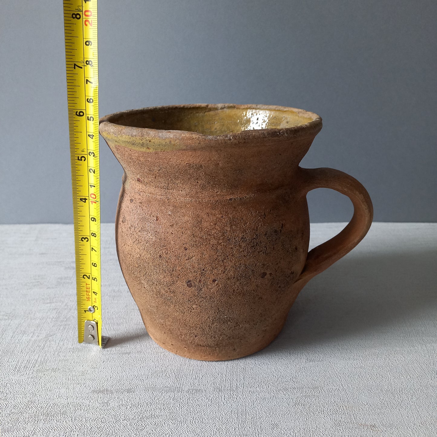 Small rustic vintage pottery jug with ochre glazed interior from France