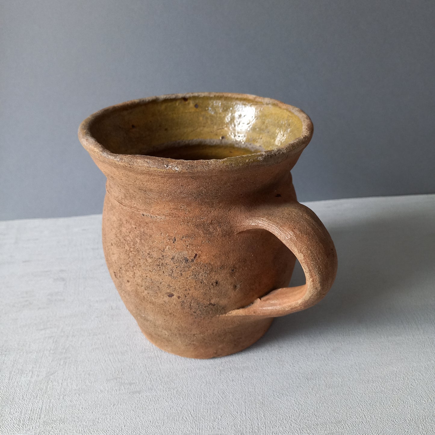 Small rustic vintage pottery jug with ochre glazed interior from France