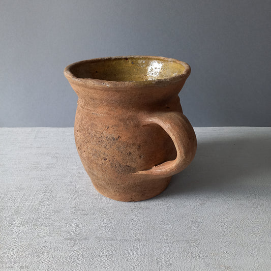 Small rustic vintage pottery jug with ochre glazed interior from France