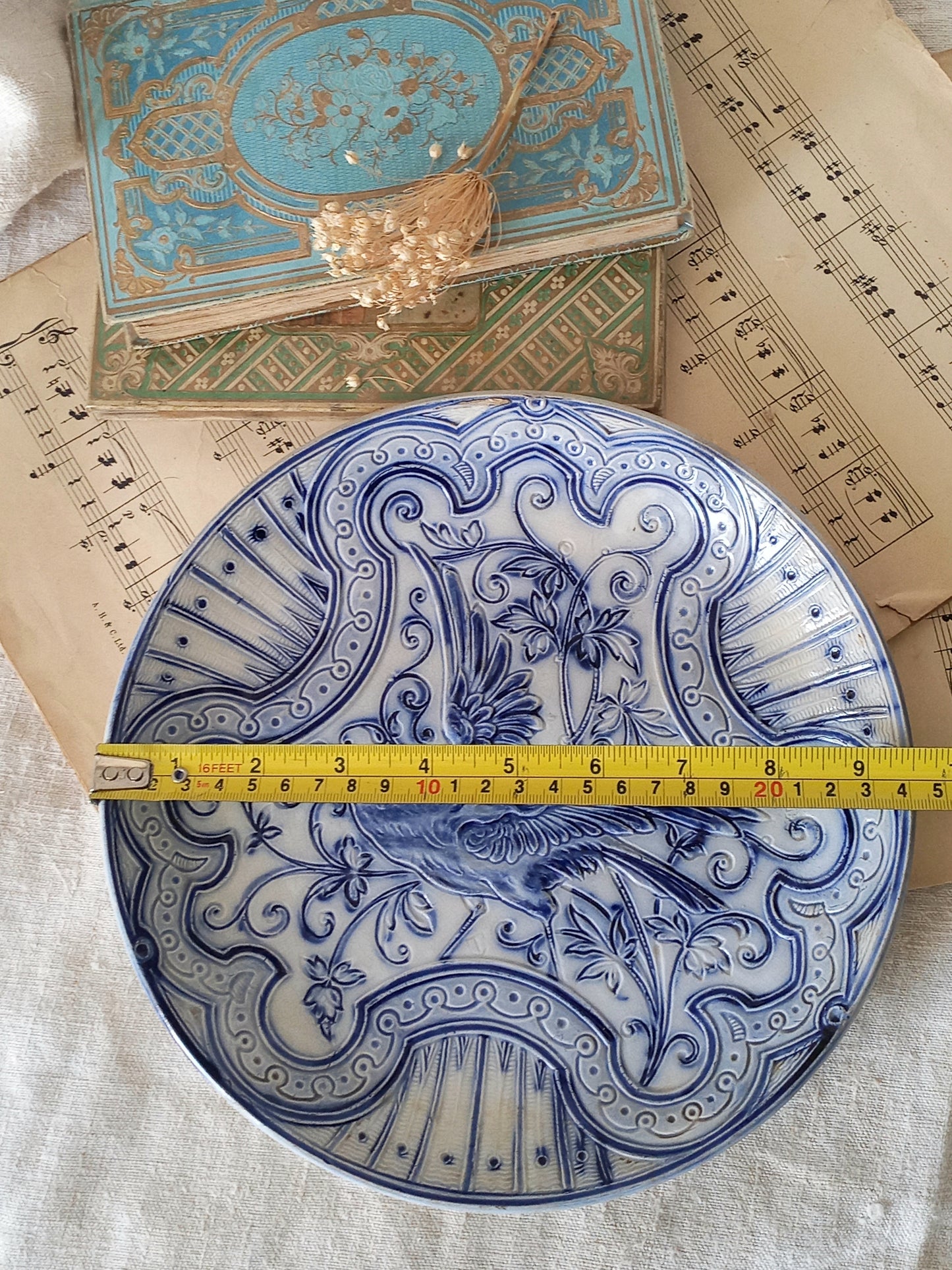 antique decorative majolica plate by premier Belgian manufacture, Wasmuel with a tape measure for reference.