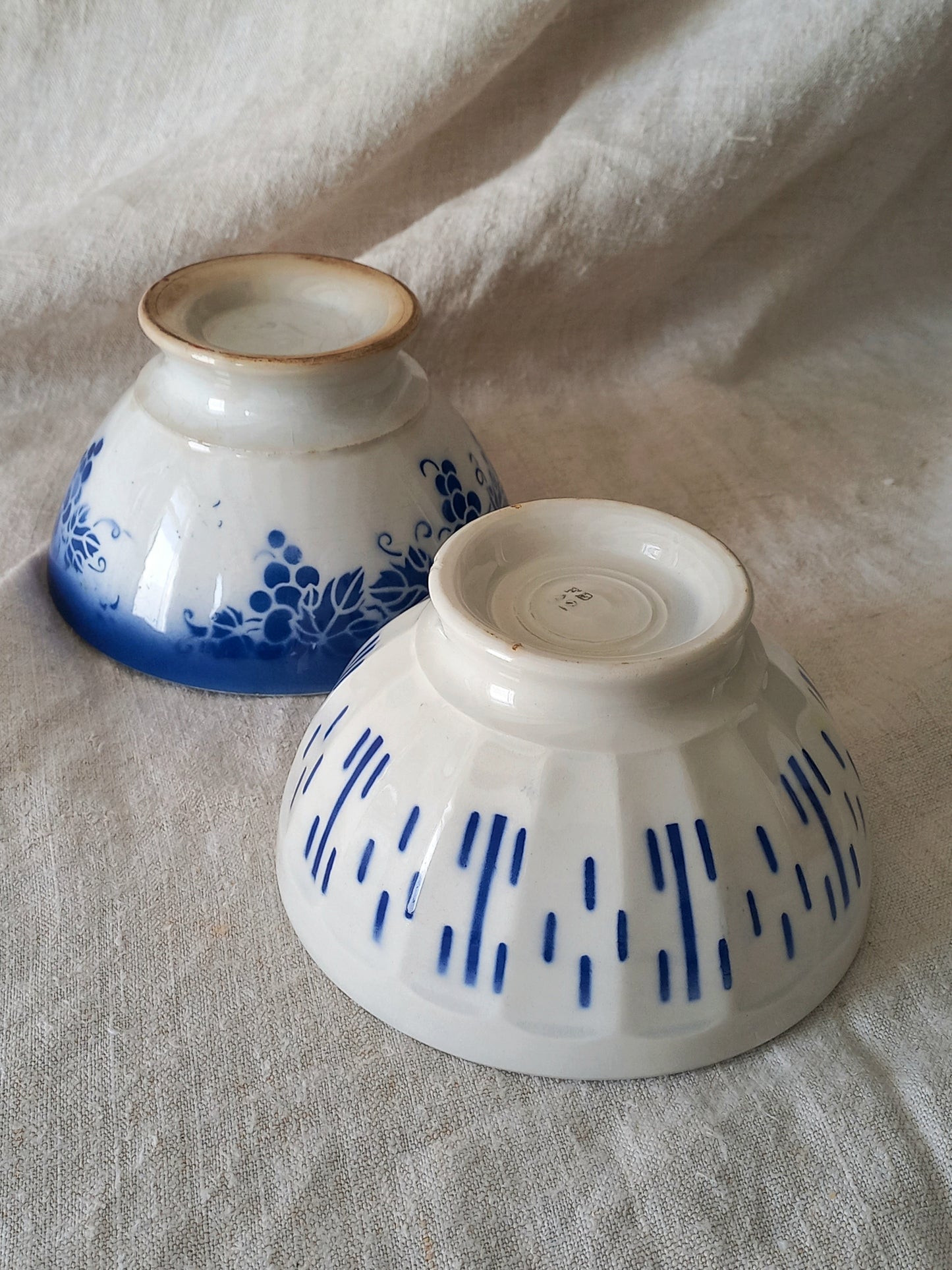 Two ceramic bowls with blue patterns on a textured surface