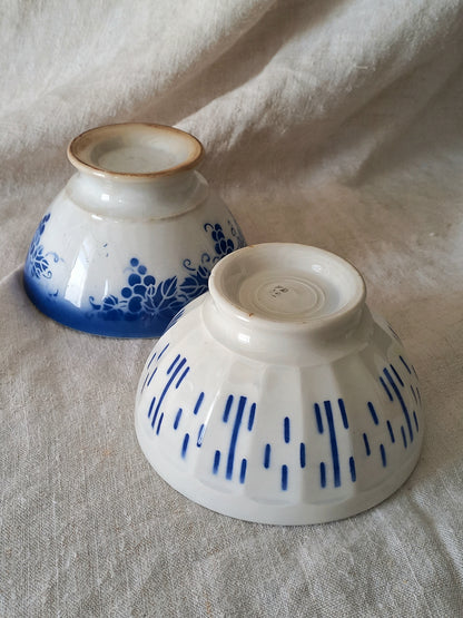 Two ceramic bowls with blue patterns on a textured surface