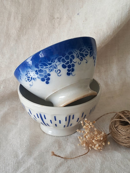Two ceramic bowls with blue floral patterns on a beige fabric background