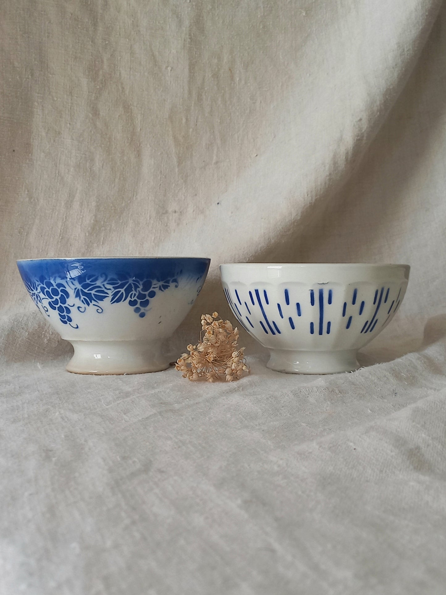 Two ceramic bowls with blue patterns on a textured beige background