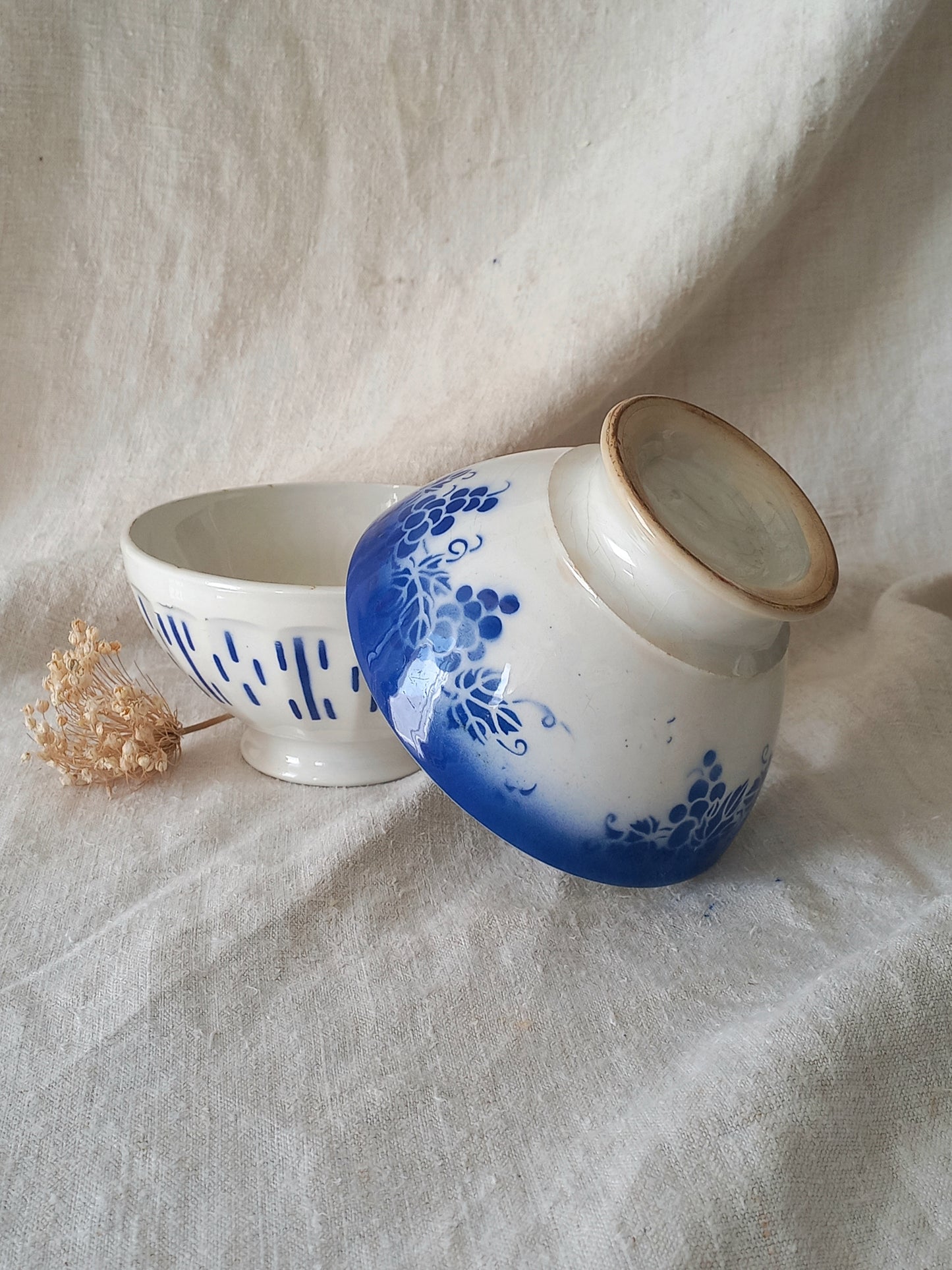 Ceramic bowls with blue floral design on a textured fabric background