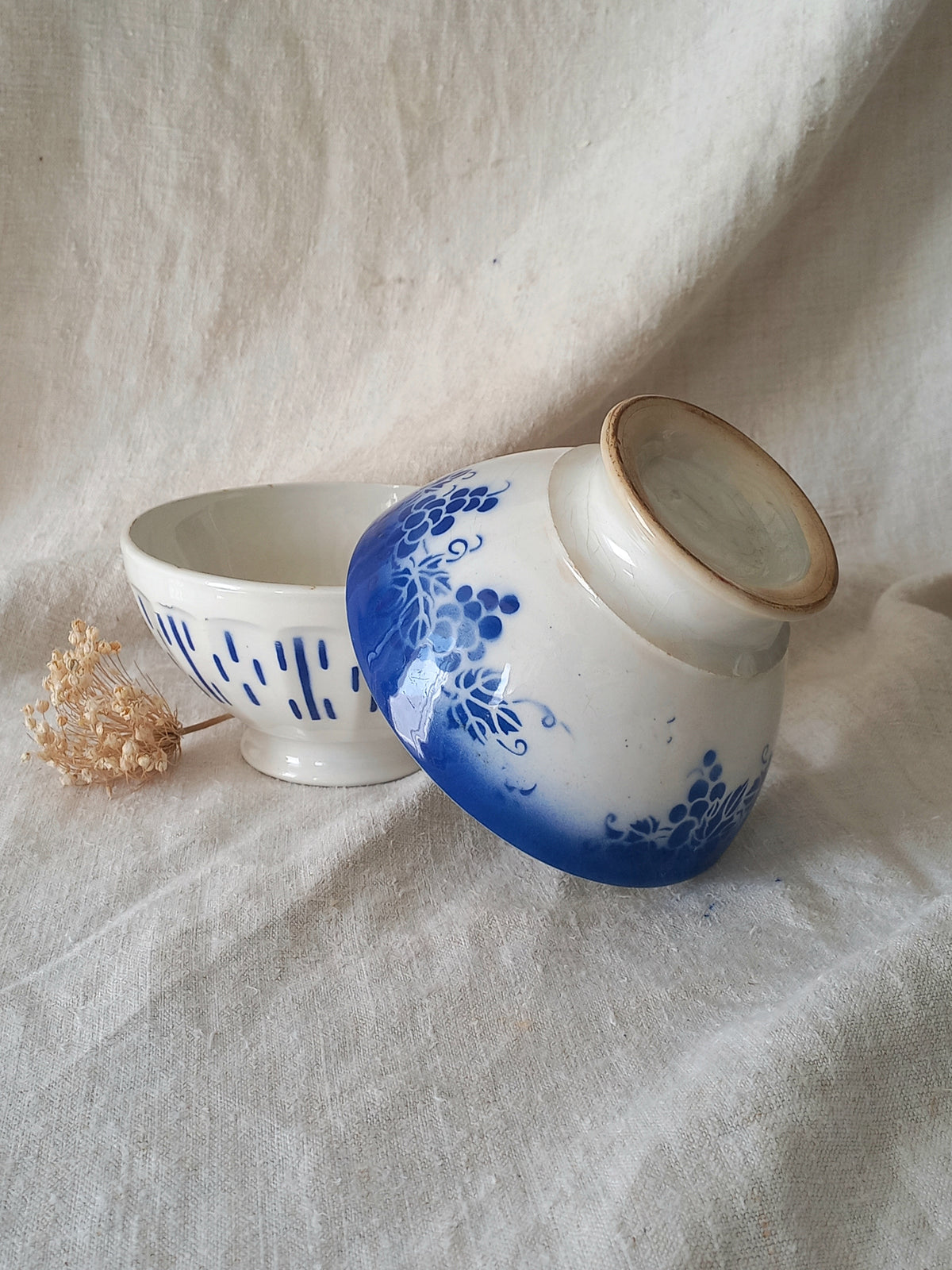Ceramic bowls with blue floral design on a textured fabric background