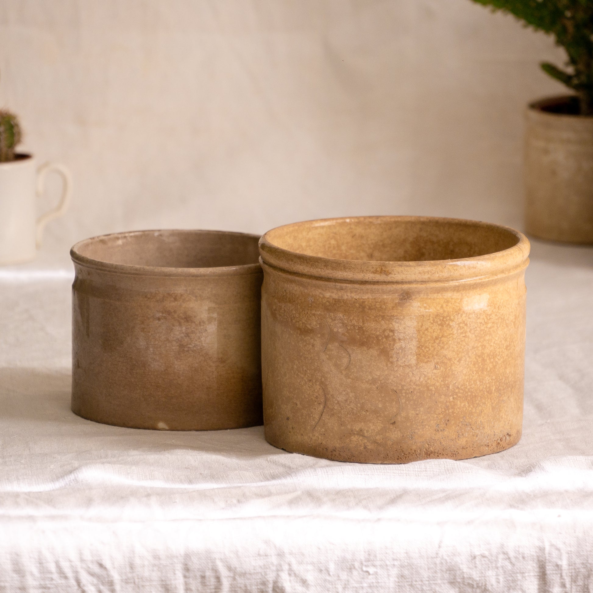 A pair of French antique tea-stained white to creamy brown ironstone crock pots or preserve pots.

In the past these small pots were quintessential pieces in French kitchens for storing jam, etc, and these days are still just as useful for items such as utensils.

Smaller pot was manufactured by Choisy le Roi, circa. late 1800s. The larger pot has no maker's mark - circa. late 1800s/early 1900s.