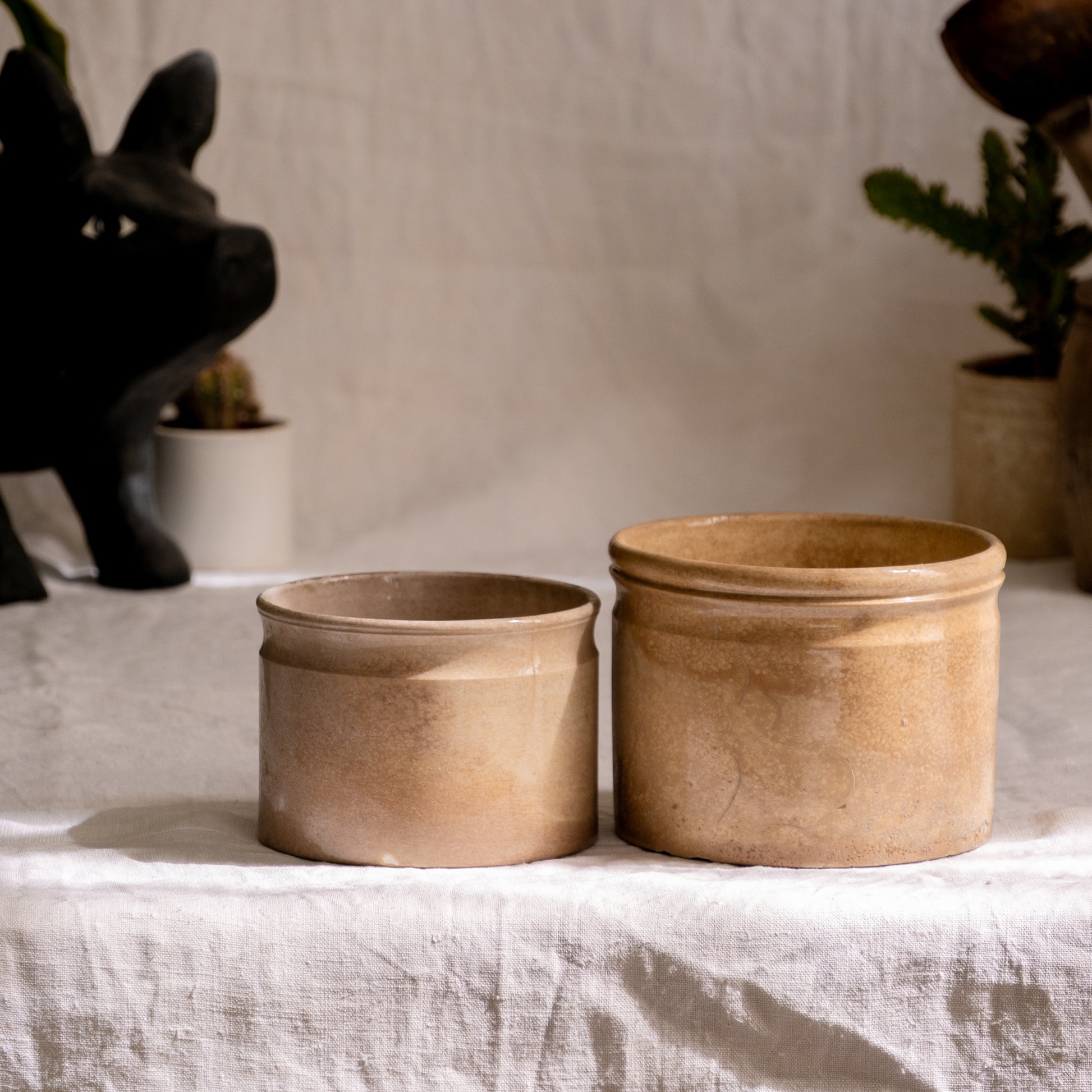 A pair of French antique tea-stained white to creamy brown ironstone crock pots or preserve pots.

In the past these small pots were quintessential pieces in French kitchens for storing jam, etc, and these days are still just as useful for items such as utensils.

Smaller pot was manufactured by Choisy le Roi, circa. late 1800s. The larger pot has no maker's mark - circa. late 1800s/early 1900s.