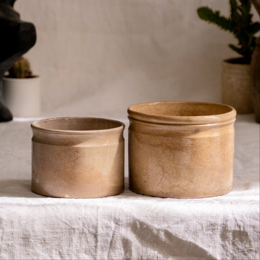 A pair of French antique tea-stained white to creamy brown ironstone crock pots or preserve pots.

In the past these small pots were quintessential pieces in French kitchens for storing jam, etc, and these days are still just as useful for items such as utensils.

Smaller pot was manufactured by Choisy le Roi, circa. late 1800s. The larger pot has no maker's mark - circa. late 1800s/early 1900s.