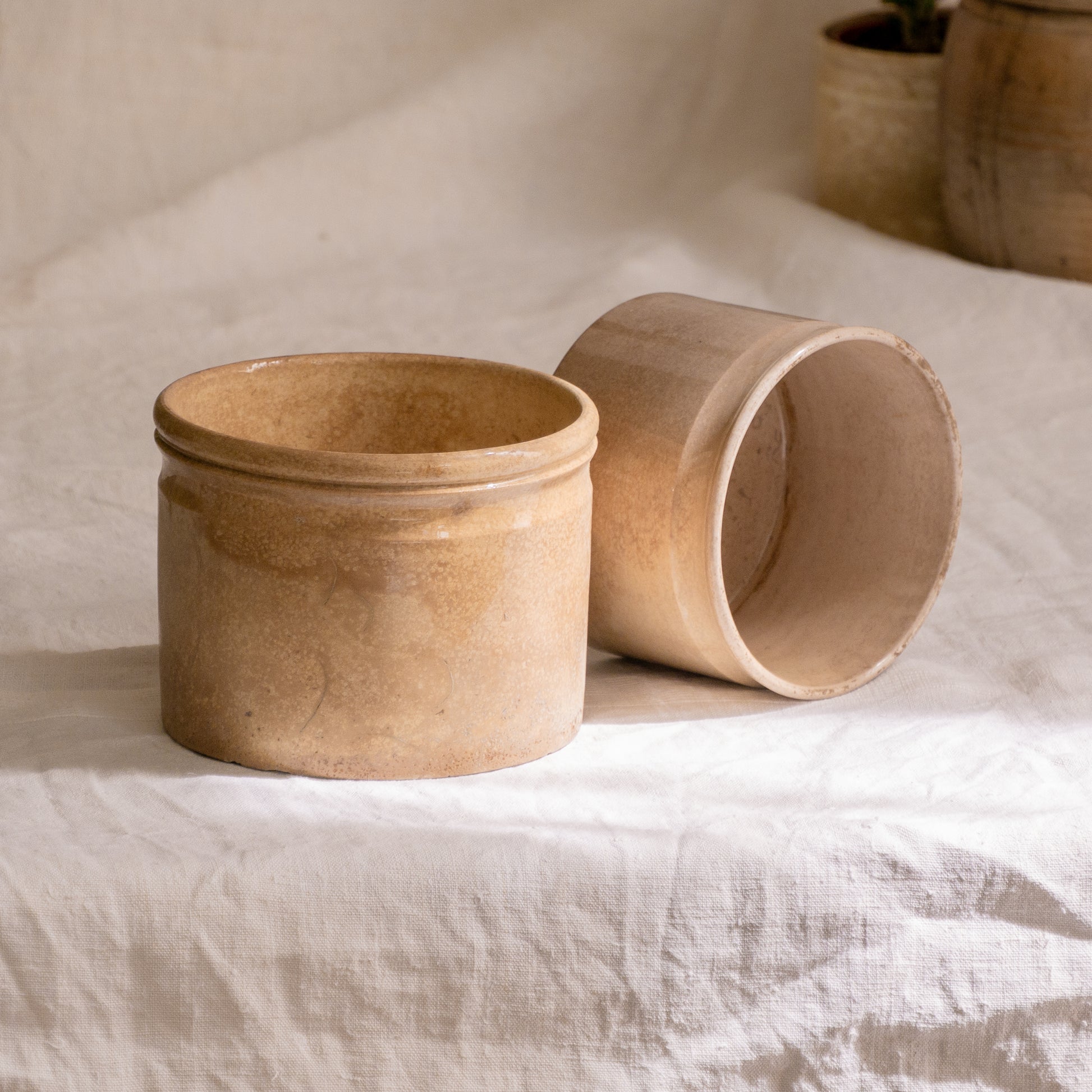 A pair of French antique tea-stained white to creamy brown ironstone crock pots or preserve pots.

In the past these small pots were quintessential pieces in French kitchens for storing jam, etc, and these days are still just as useful for items such as utensils.

Smaller pot was manufactured by Choisy le Roi, circa. late 1800s. The larger pot has no maker's mark - circa. late 1800s/early 1900s.