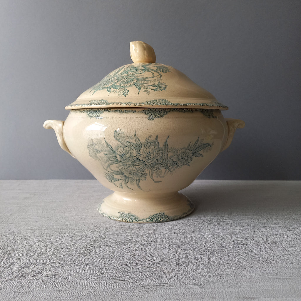 A pretty antique ironstone soup tureen with aged and faded floral transfer pattern in a beautiful shade of blue green or teal. Over time this wonderful old tureen has developed a pleasing faded creamy white finish. In summary, a beautiful piece of authentic antique ironstone from France.
