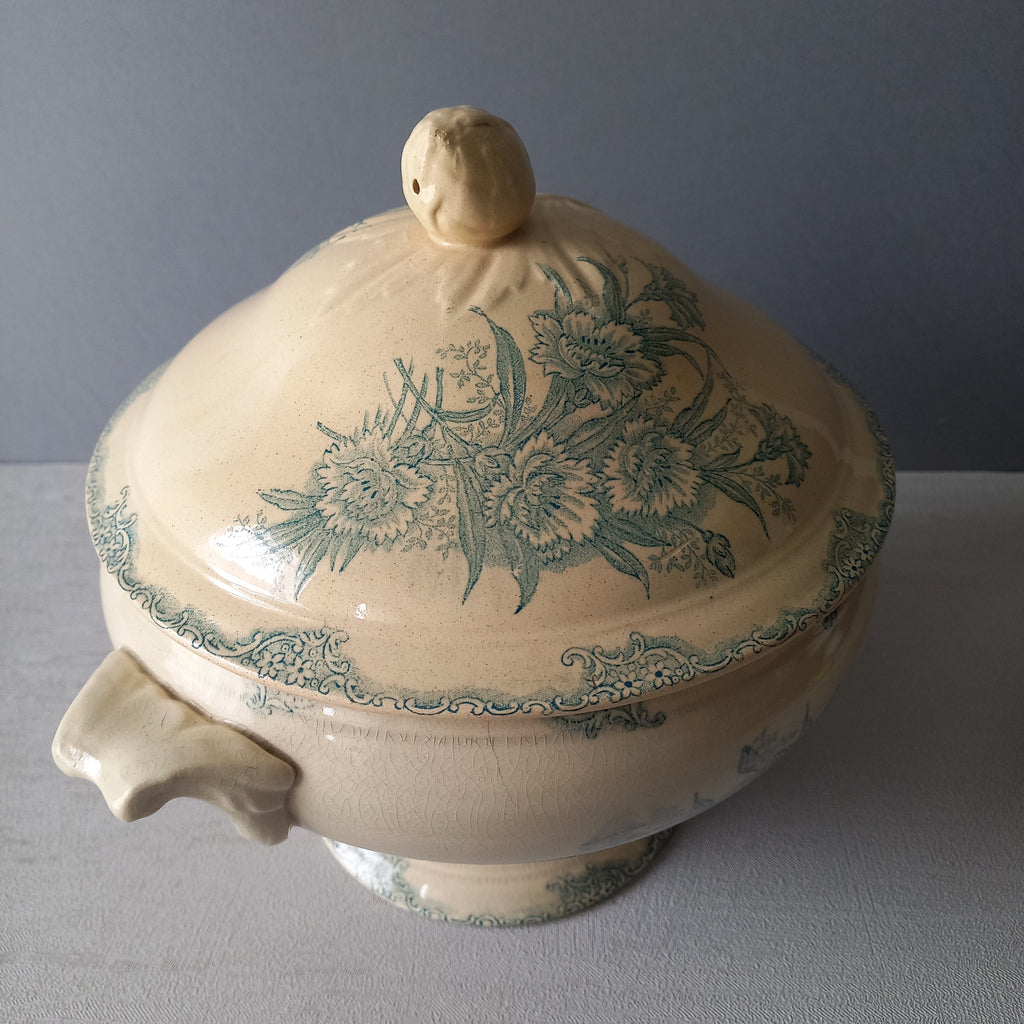 A pretty antique ironstone soup tureen with aged and faded floral transfer pattern in a beautiful shade of blue green or teal. Over time this wonderful old tureen has developed a pleasing faded creamy white finish. In summary, a beautiful piece of authentic antique ironstone from France.