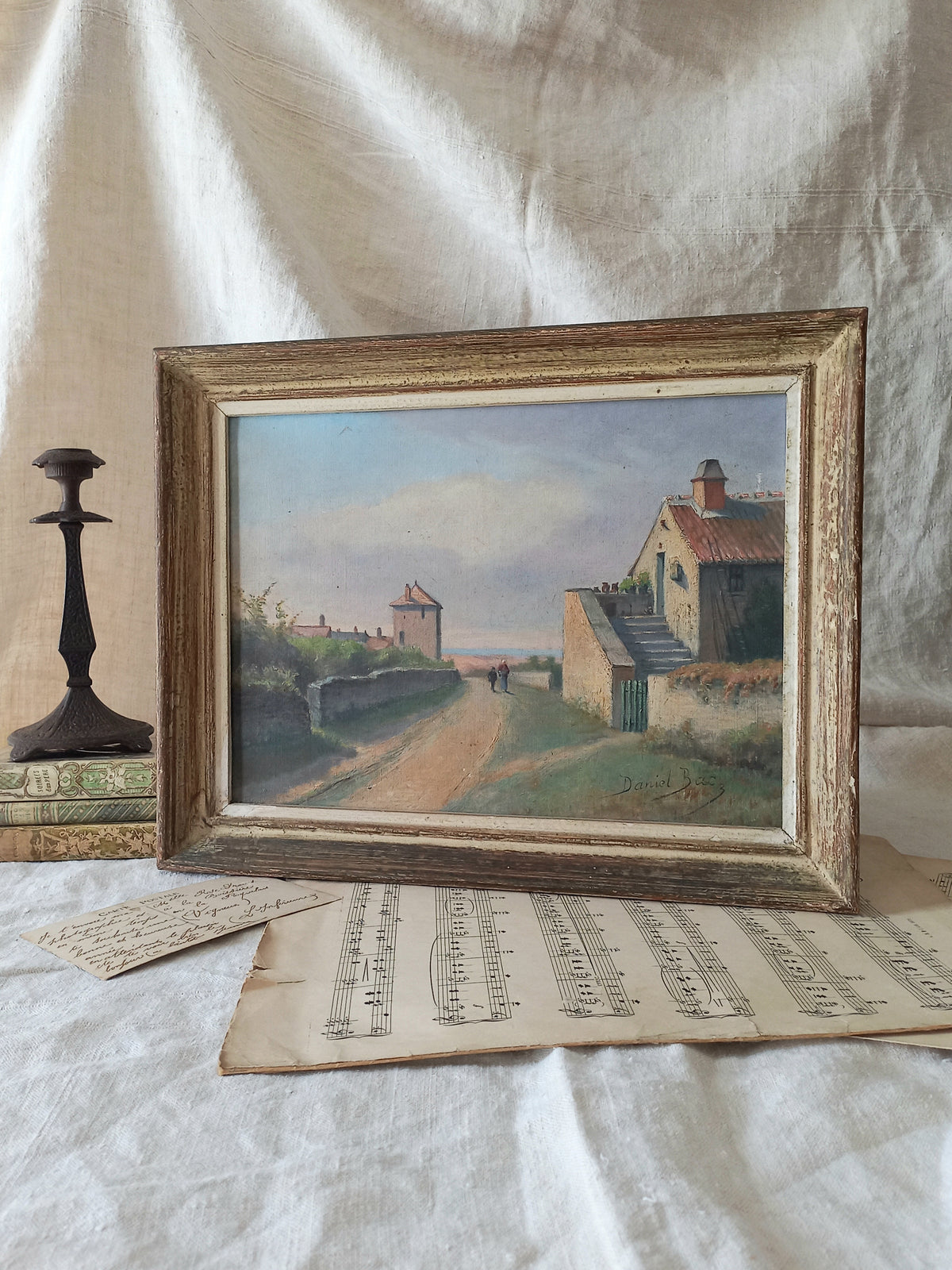 Framed painting of a landscape with houses on a textured surface