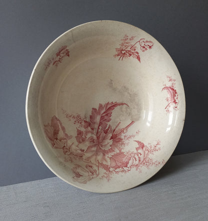 A large French vintage ironstone bowl with beautiful deep pink floral pattern on a creamy white base colour. Over the years this old bowl has aged nicely with crazing, tea-staining, and the odd little imperfections that show this as an authentic antique piece.

There is a maker's mark on the base. Circa. late 1800s/early 1900s.