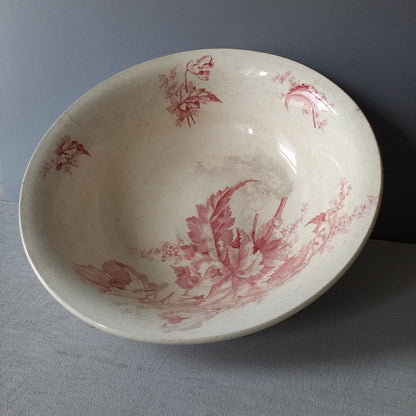 A large French vintage ironstone bowl with beautiful deep pink floral pattern on a creamy white base colour. Over the years this old bowl has aged nicely with crazing, tea-staining, and the odd little imperfections that show this as an authentic antique piece.

There is a maker's mark on the base. Circa. late 1800s/early 1900s.