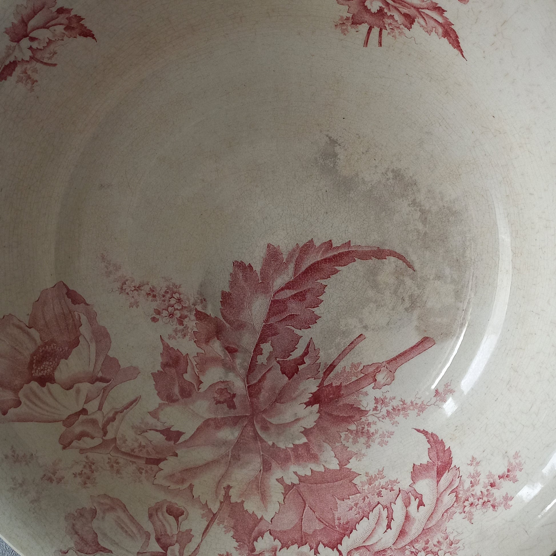 A large French vintage ironstone bowl with beautiful deep pink floral pattern on a creamy white base colour. Over the years this old bowl has aged nicely with crazing, tea-staining, and the odd little imperfections that show this as an authentic antique piece.

There is a maker's mark on the base. Circa. late 1800s/early 1900s.