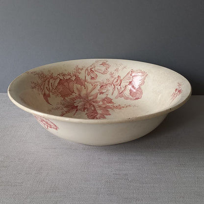 A large French vintage ironstone bowl with beautiful deep pink floral pattern on a creamy white base colour. Over the years this old bowl has aged nicely with crazing, tea-staining, and the odd little imperfections that show this as an authentic antique piece.

There is a maker's mark on the base. Circa. late 1800s/early 1900s.