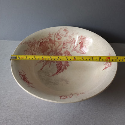 A large French vintage ironstone bowl with beautiful deep pink floral pattern on a creamy white base colour. Over the years this old bowl has aged nicely with crazing, tea-staining, and the odd little imperfections that show this as an authentic antique piece.

There is a maker's mark on the base. Circa. late 1800s/early 1900s.